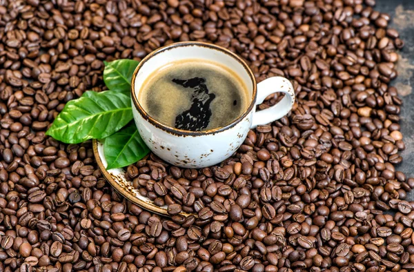 Bebida de café preto folhas verdes grãos de café fundo — Fotografia de Stock