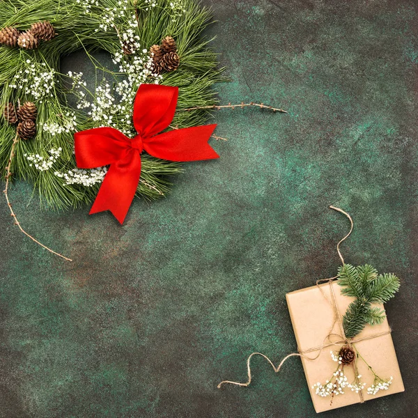Vánoční věnec červenou stuhou luk zabalený dárek — Stock fotografie
