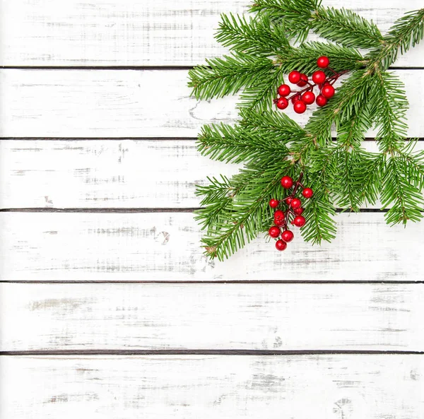 Árbol de Navidad ramas bayas rojas decoración fondo de madera — Foto de Stock