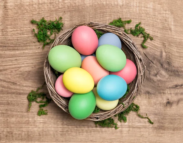 Easter eggs in basket wooden background