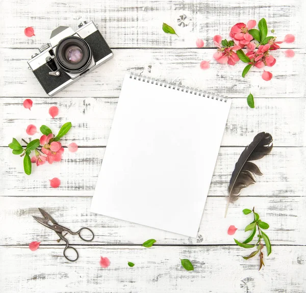 Plano poner papel cuaderno de bocetos foto cámara rosa flores de primavera — Foto de Stock