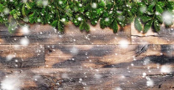 Χριστουγεννιάτικο δέντρο κλαδιά πτώσης χιονιού φόντο ξύλινη — Φωτογραφία Αρχείου