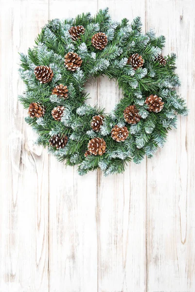 Ghirlanda di Natale con coni decorazione sfondo in legno — Foto Stock
