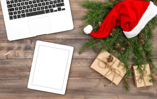 Oficina escritorio Navidad decoración rojo sombrero regalos Laptop tablet — Foto de Stock