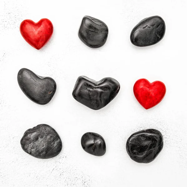 Červené srdce černé kameny lásky Valentýna ploché rozložení pozadí — Stock fotografie