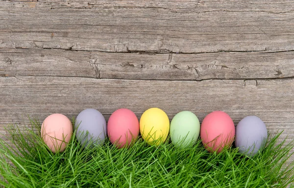 Påsk ägg grönt gräs rustikt trä bakgrund — Stockfoto