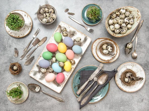 Easter decoration colorful eggs green plants table setting — Stock Photo, Image