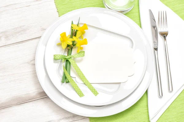 Spring table decoration narcissus flowers White plate fork knife — Stock Photo, Image