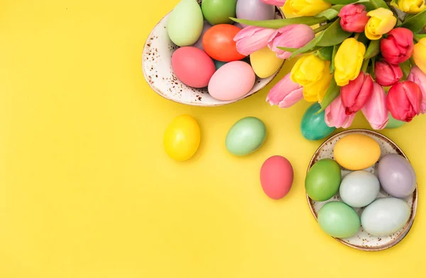 Paskalya yumurtaları dekorasyon lale çiçekleri sarı arka plan — Stok fotoğraf