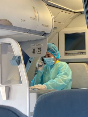 VIETNAM, HO SHI MIN CITY - 20 Mart 2020: uçuş personeli hostesi eldiven ve maske takıyor ve Vietnam Havayolları 'ndan uçağa biniyor. Coronavirus. Salgın hastalık. Salgın