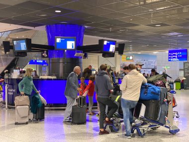 FRANKFURT, GERMANY - 21 Mart 2020: Frankfurt, Almanya Havaalanı 'nda koruyucu maske takan gezginler. Corona virüsü pandemi