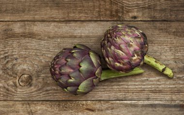 Kırsal ahşap arka planda enginar sebzesi. Çiğ gıda malzemeleri.