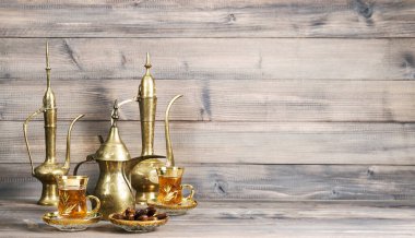 Tarihli çay masası ve ahşap arka planda altın oryantal süslemeler.