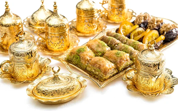 Arabic food delight, tea cups and golden decorations. Oriental hospitality