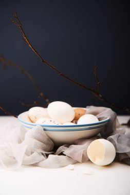 Kadınsı Paskalya kavramı. Beyaz yumurta bir kapta. Koyu arka plan.