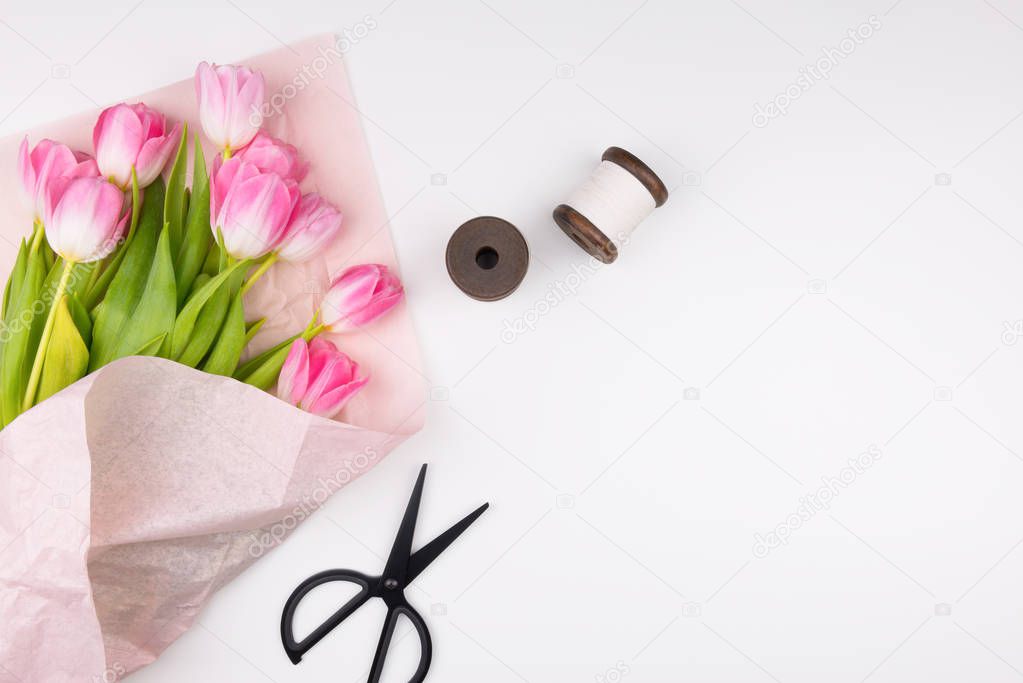 Minimal styled flat lay with pink tulips flowers with petals in 