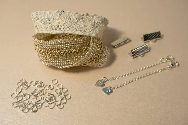 Luxury silver and golden gentle hand made decorations skin and beige color concept fashion production jewellry. Delicious home-made goods, manufacturing lace braceles with silver mount and chain.