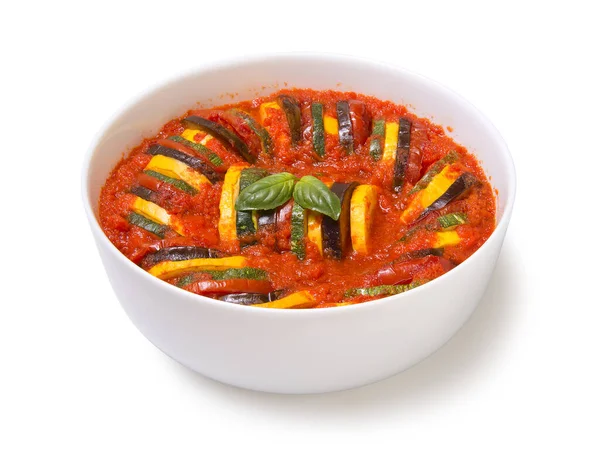 Beyaz arka planda izole edilmiş beyaz bir güveçte sebzeli ratatouille.