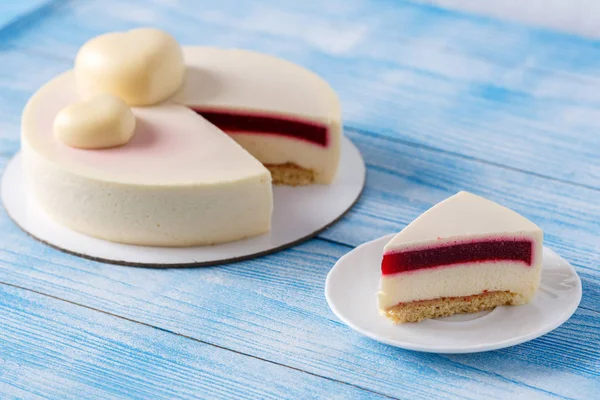 Trendy mousse cake. Slice of cake on a plate Wooden background.