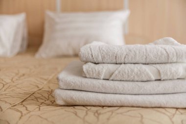 Yatak yatak odası iç beyaz otel havlu yığını.