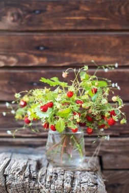 Berry buket bir cam ahşap arka plan üzerinde