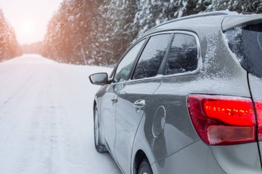 Karlı havada, kışın vajina yolunda gri bir araba. Yan görünüm