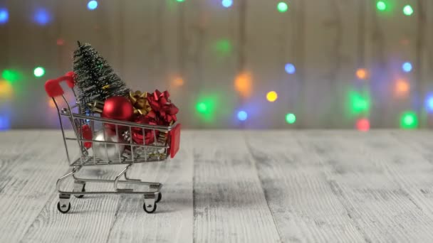 圣诞树和礼物在一个迷你购物车的背景上的领先的灯具花环 圣诞甩卖的概念 — 图库视频影像