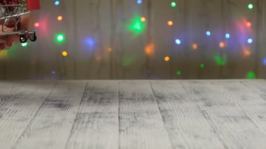 El, Noel ağacının olduğu mini alışveriş arabası ve arkaplandaki lambaların arasına da hediyeler koyar. Noel indirimi kavramı
