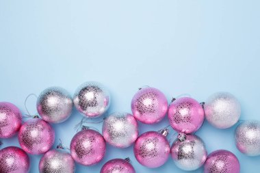 Noel kompozisyonu Pembe, gümüş toplar ve mavi arka planda parıltılar. Noel, kış, yeni yıl konsepti