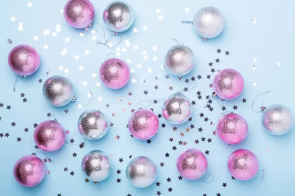 Kerstcompositie Roze, zilveren ballen en sprankelingen op pastelblauwe achtergrond. Kerstmis, winter, nieuwjaarsconcept — Stockfoto