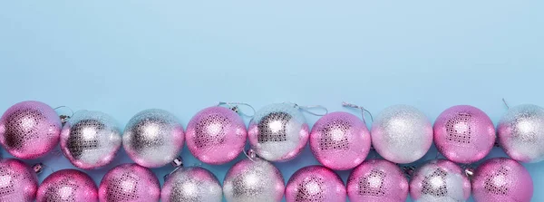 Kerstcompositie Roze en zilveren ballen op pastelblauwe achtergrond. Webbanner. Kerstmis, winter, nieuwjaarsconcept — Stockfoto