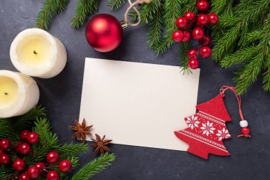 Kağıt, hediye kutusu ve arka planda köknar ağacı dalı olan mutlu noel kartları. Kırmızı aksesuarlar. Üst görünüm