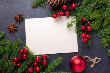 Kağıt, hediye kutusu, kutsal böğürtlen ve köknar ağacı dallı mutlu noel kartları. Üst görünüm