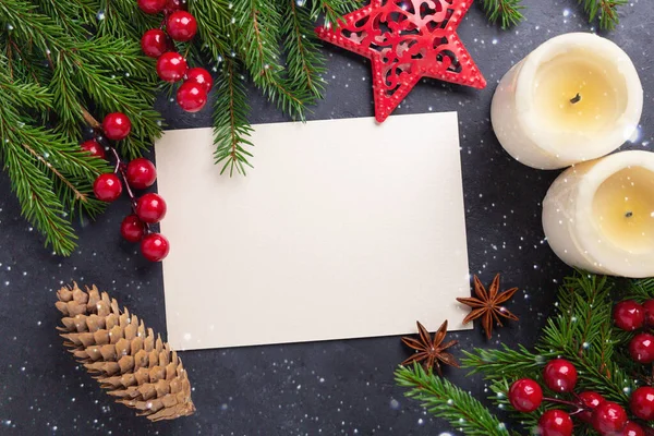 Kağıt, hediye kutusu, mumlar ve arka planda köknar dalı olan mutlu noel kartları. Kırmızı aksesuarlar. Üst görünüm