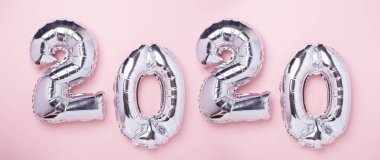 Pembe arka planda 2020 numara şeklinde gümüş balonlar. Yeni yıl kutlaması. Mutlu yeni yıl kavramları