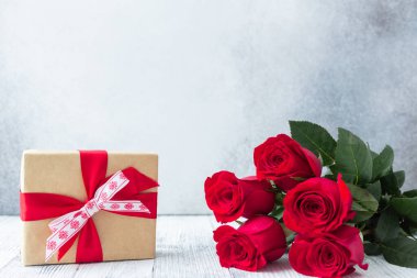 Kırmızı gül buketi ve arka planda hediye kutusu Sevgililer Günü tebrik kartı