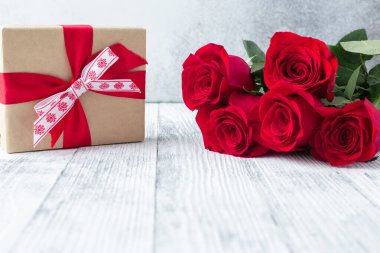 Kırmızı gül buketi ve arka planda hediye kutusu Sevgililer Günü tebrik kartı