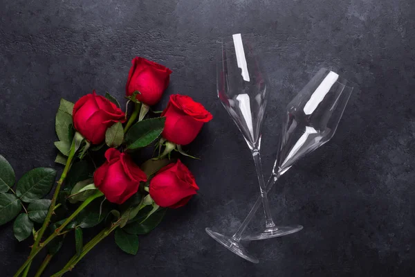 Vermelho rosa flores buquê, copos de champanhe no fundo de pedra preta Dia dos Namorados cartão espaço de cópia — Fotografia de Stock