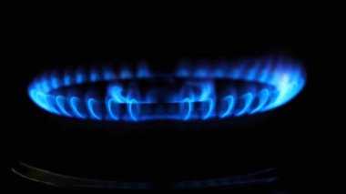 Siyah arka planda mavi gaz ocağı alevi. Gaz düğmesi açık. Doğal gaz kontağı, kapat.