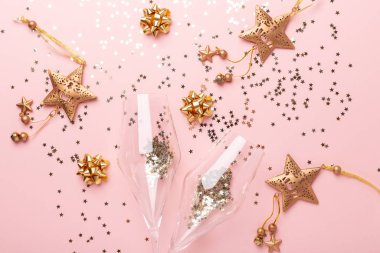 Noel yatağı. Şampanya kadehleri ve pembe arka planda altın madalyalar.