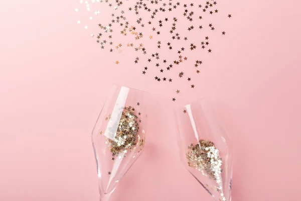 El piso de Navidad. Copas de champán y decoración dorada sobre fondo rosa —  Fotos de Stock