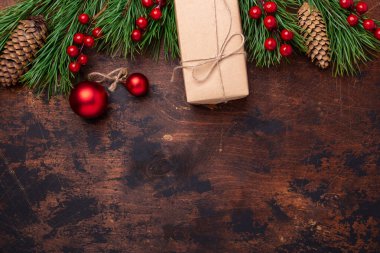 Noel tebrik kartı, içinde köknar ağacı dalı, hediyeler ve hediye kutusu var. Ahşap arka plan. Üst Görünüm Kopyalama alanı