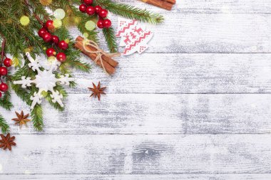 Noel arkaplanı köknar ağacı, çoban püskülü ve ahşap masa süsü. Hafif bokeh.