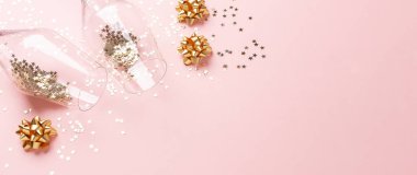 Noel yatağı. Şampanya kadehleri ve pembe arka planda altın madalyalar.