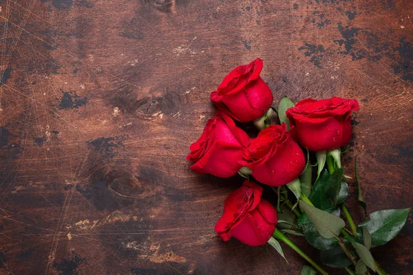 Röd ros blommor bukett på trä bakgrund Alla hjärtans dag gratulationskort Kopiera utrymme Ovanifrån — Stockfoto