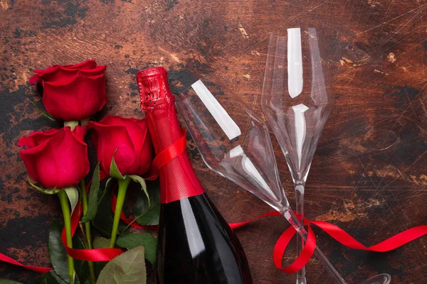 Открытки на день Святого Валентина с красными цветами розы и бокалами шампанского на деревянном фоне — стоковое фото
