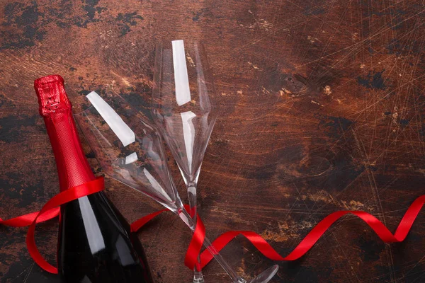 Открытки на день Святого Валентина с бокалами шампанского, бутылкой и красной лентой на деревянном фоне — стоковое фото