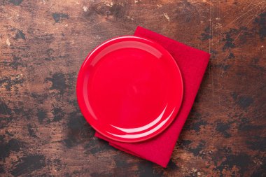 Kahverengi ahşap zemin üzerinde boş seramik kırmızı tabak Üst görünüm kopyala