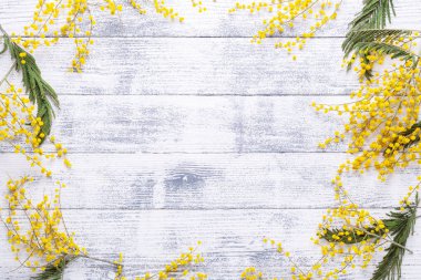 Mimosa flowers on a wooden table. Frame of flowers. Top view. Copy space