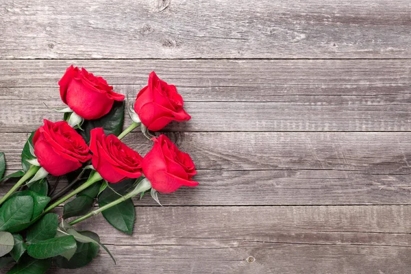 Flores de rosas vermelhas na mesa de madeira cinza. O cartão de felicitações do Valentine. Vista superior. Espaço de cópia — Fotografia de Stock